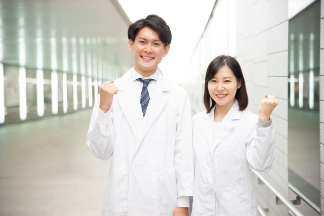明るい表情でガッツポーズの医師たち