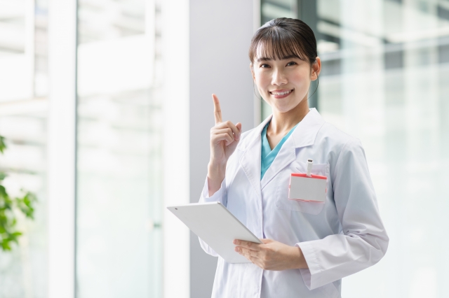 指を立てる女性医師の笑顔