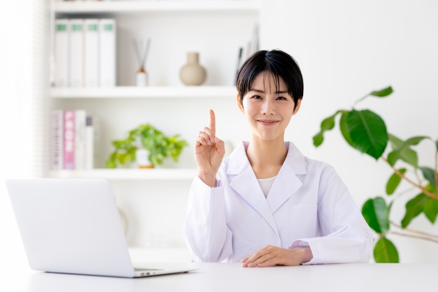 白衣の女性と指を立てた仕草