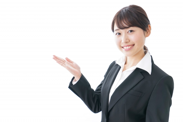 手で何かを示すスーツ姿の女性